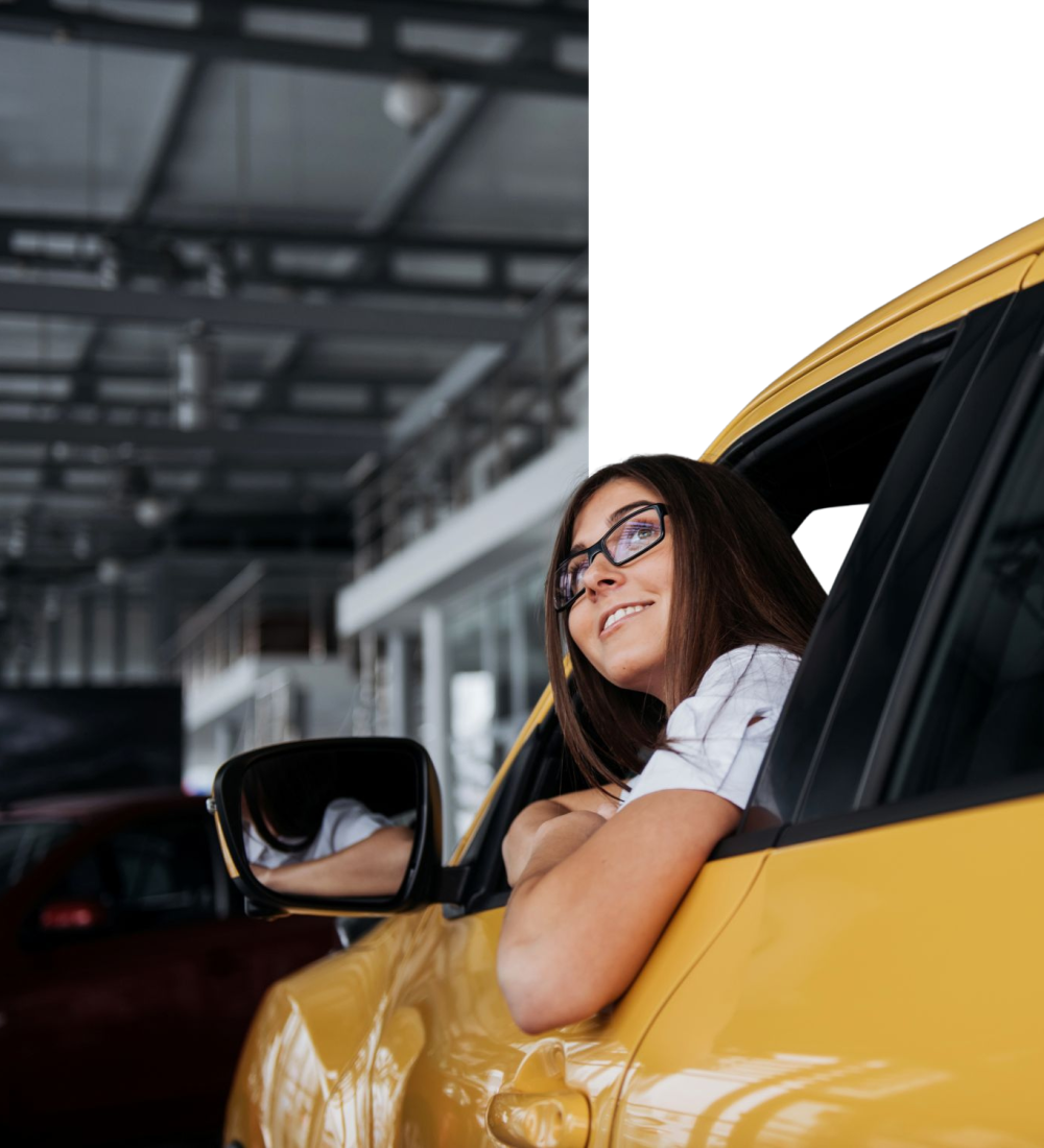 smiling-woman-inside-a-yellow-car-looking-up-2026-01-09-00-39-43.png